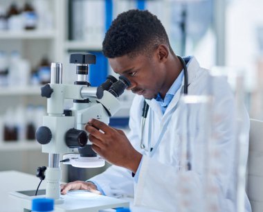 Laboratuvarda mikroskopla biyoteknoloji, araştırma ya da tıbbi mühendislik yapan bilim, araştırma ve siyahi bir adam. Analiz, laboratuvar teknisyeni veya bilim adamı aşı örneğini ilaç testi için kontrol ediyor.