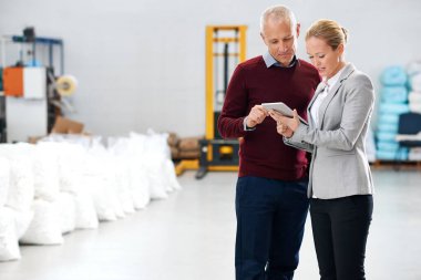 Lojistik, depo ve iş adamları takım çalışması, tedarik zinciri ve ekomünikasyon için tablet kullanıyorlar. Olgun erkek, kadın ve dijital teknoloji ile planlama, iletişim veya sohbet için tartışma.