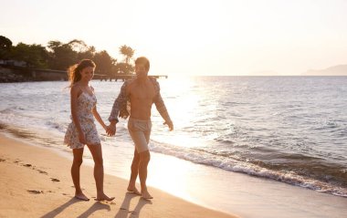 Aşk, gün batımı ve tropik tatil maceraları için sahilde yürüyen çift, rahatlayın ve kaynaşın. Doğa, erkek ve kadın okyanus, ada ve akşam dalgalarıyla romantik bir randevuda. Mutlu tatiller.