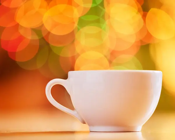 Bokeh, background and coffee cup for warm drink, fine china or porcelain with crockery, catering and kitchenware. Color, light and ceramic drinkware with breakfast or break time beverage at cafe.