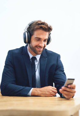 Kulaklıklar, ofis ve iş adamları sosyal medya için cep telefonlu, internette gezinen veya müzik yayınlayan. Gülümse, akıllı telefon ve erkek kişi radyo, ses podcast veya online Ted Talk dinliyor.