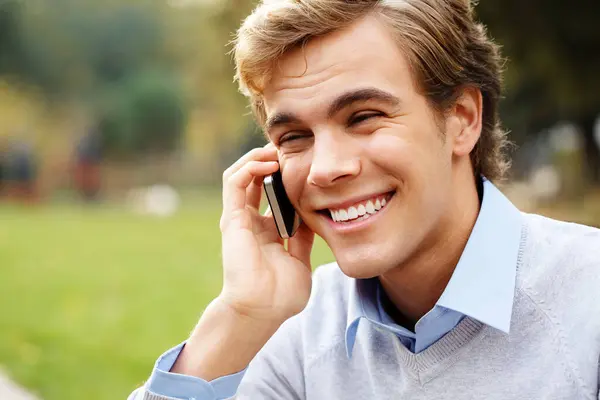 Phone call, student and man with smile, park and nature to relax in university, talking and listening to contact. Communication, scholarship and technology for guy, knowledge and campus in USA.