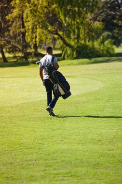 Spor, çanta ve golf sahasında bir adamla ya da sporcuyla lüks tatillerde ya da tatilde. Yazın çimenlikte çim, tarla ve egzersiz yapmak için kırsal kesimde çalışanlarla birlikte..