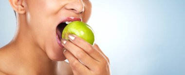 Isırık, elma ya da ağız sağlıklı seçim için yemek yiyen ya da mavi arka planda yer kaplayan bir kadın. Stüdyoda taze, el ya da vejetaryen kız meyve, lif, detoks diyeti ya da C vitamini için yiyecek ya da.