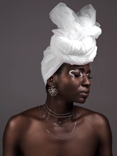 Face, wrap and black woman with makeup, skincare or confidence in studio on grey background. Beauty, profile or proud African model with traditional culture, eyeshadow cosmetics or creative necklace.