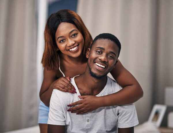 Black couple, portrait and smile in home bedroom for relaxing together, bonding or comfortable. Man, woman and face with hugging embrace in apartment for happy relationship with care, peace or calm.