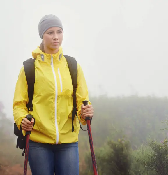 Woman, trekking and fitness in nature with pole for backpacking, travel and outdoor adventure. Journey, path and female person in hiking gear for exercise, balance or health in forest trail