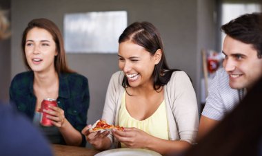 Pizza, komik ve sosyal bir toplantı. Bir grup arkadaş restoranda kaynaşmak için birlikte yemek yiyorlar. Gülümseyin, mutlu olun ya da genç kadın ve erkeklerle gülün açlık ve sohbet için fast food yiyin..
