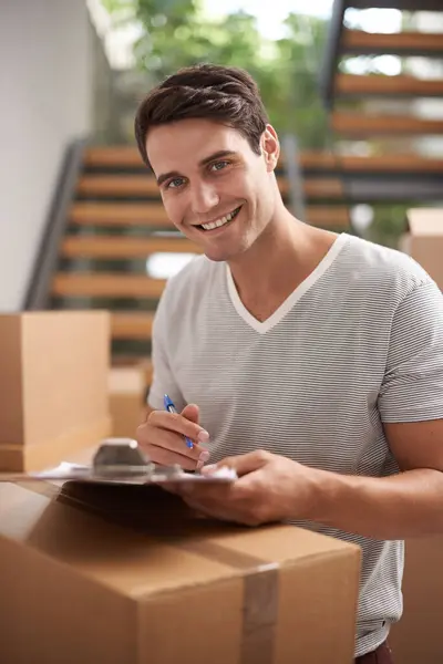 Man, boxes and portrait with clipboard for moving, delivery and documents for logistics, smile and invoice. Person, cardboard and package with paperwork for service, signature and stock in new house.