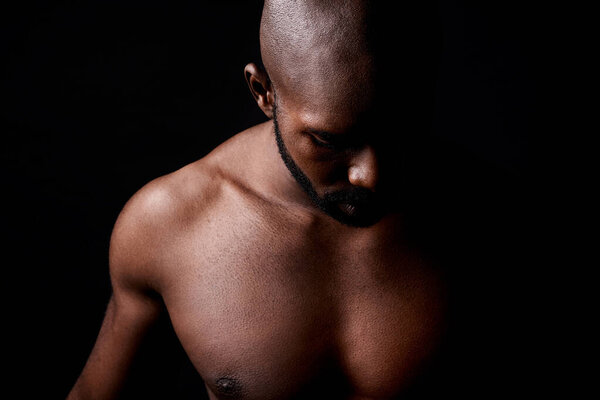 Black man, muscle and fitness with shadow for workout or exercise on a dark studio background. Closeup of young African male person or bodybuilder with masculine or muscular body on mockup space.