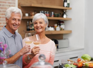 Yaşlı çift, mutfakta portre ve tost, emeklilik için şarap, kutlama ve dairede aşk. Yaşlı adam, kadın ve tatil için mutluluk, bağlılık ve sağlık tatil için evde.