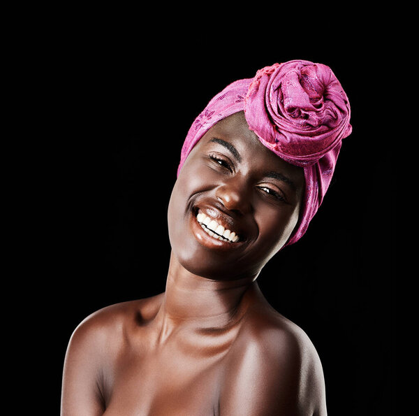Black woman, head wrap and beauty portrait with smile, skincare and natural cosmetics in studio. Traditional, turban and African fashion with wellness and skin glow with makeup and dark background.
