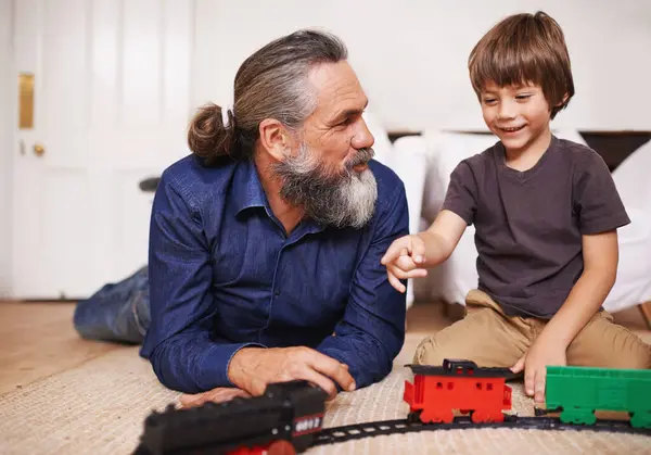 玩玩具火车 在家里或家里玩得开心 成熟的男人 孩子和幸福 带着微笑 青春和童年的发展 共同促进未来的成长 联系或关怀 — 图库照片