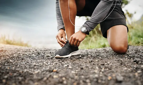 Person, hands and shoelace with running for fitness to exercise, health and wellbeing in outdoor. Above, sneakers and committed on workout or jog in morning for training, wellness and self care.