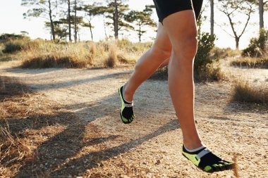 Bacaklar, koşu ve spor, kardiyo ve sağlık eğitimi için parka gelen biri. Atletizm, hız ve eylemde toprak yolda koşucu ile yarış, antrenman ve dayanıklılık ile egzersiz.