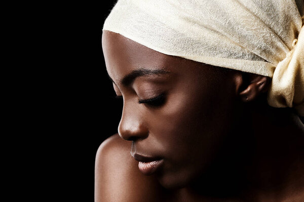 Beauty, relax and black woman in studio with headscarf, natural makeup or creative aesthetic. Art, skincare and African girl on dark background with head wrap, facial cosmetics and culture in profile.