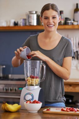 Portre, gülümseme ve smoothie, beslenme ya da ev mutfağındaki masada sağlıklı beslenmek için blender kullanan kadın. Mutlu insan, yüz ve meyve karıştırıcı, sağlıklı olmak için çilek ve organik muz..