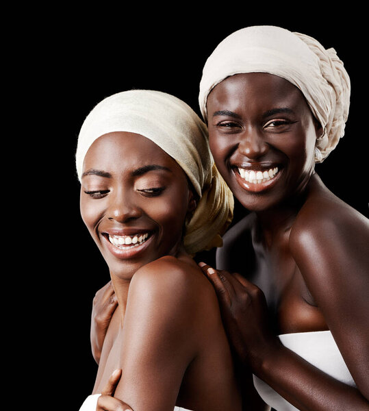 Black women, head wrap and beauty portrait with smile, skincare and cosmetics in studio with bonding. Girl friends, happy and African scarf with wellness and skin glow with makeup and dark background.