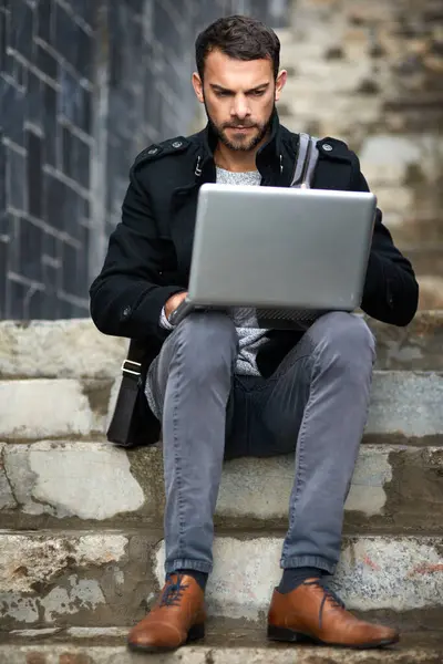 Man, typing and laptop on stairs for remote work, email, and research for writing. Creative, male person and copywriter with computer for freelance articles or blog outdoors in urban New York.