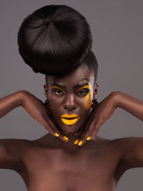 Afrikalı, kadın ve stüdyo portresi makyaj, güzellik ve yaratıcı sarı ruj. Kendine güvenen cesur, manken ve ten, dramatik saçlar ve cazibe için çörek ve gri arka planda moda kozmetik ürünler..