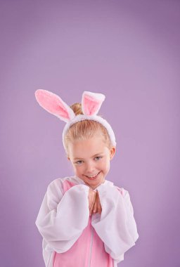 Portre, tavşan ve kostüm, mutluluk ve cadılar bayramı kıyafeti ile mor bir stüdyo arka planında. Yüzü, çocuğu ve mankeni tavşan gibi giyinmiş, karakterli, gülümsemeli ve kültürlü Paskalya tatili.