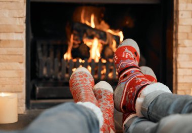 Çiftler, Noel 'i ve çorapları şöminenin yanında kutlayalım evde rahatlayalım, kışın romantik ve bağ kuralım. İnsanlar, bacaklar ve ev için sıcak, birlikte ve konfor, yün ve ısı için sevgi.