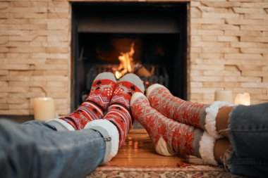 Noel, çoraplar ve şöminenin yanında kutlamalar için evde dinlenmek için, kışın romantik ve bağ kurmak için. İnsanlar, bacaklar ve yeni yıl için sıcak, birlikte ve konfor, yün ve ısı için sevgi.