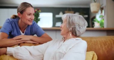 Sağlık hizmeti, gülümseme ve yaşlı bir kadınla danışmanlık ya da yardım için oturma odasındaki kanepede sohbet etmek. Emeklilik dairesindeki kıdemli hastayla sağlık, sohbet ve mutlu bakıcı..