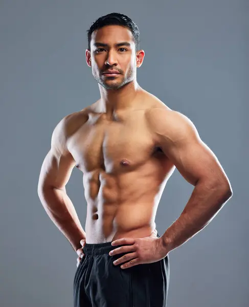 Portrait, man and fitness for muscle in health, wellness and workout in studio background for sports training. Male person, athlete and strong for progress as bodybuilder for results in grey backdrop.