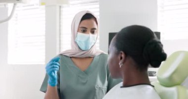 Müslüman kadın, dişçi ve hasta diş bakımı, diş temizliği ya da klinikte tedavi için danışmanlık yapıyorlar. Genç bayan ya da ortodontist müşteri oral, sakız ya da diş beyazlatma için danışmanlık.