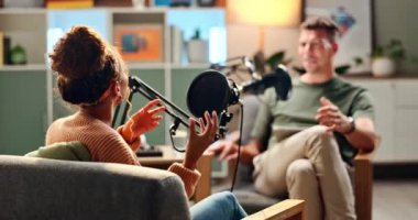 Mutlu insanlar stüdyoda tartışma, konuşma ya da haber için podcast 'le röportaj yapıp gülüyorlar. Genç adam ve kadın canlı yayında ya da mikrofonla iletişim, canlı sohbet ya da kayıt için sohbet programında.