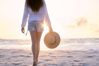 Plaj, gün batımı ve tatilde, tatilde ya da yaz tatilinde Hawaii 'de gezen kadın bacakları. Sırt, okyanus ve ayaklar denizde kumların üzerinde macera, yolculuk ya da taklit uzay şapkası ile doğada.
