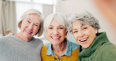 Selfie, eğlence ve kıdemli bayan arkadaşlar birlikte emeklilik sürecinde bir evde kaldıkları için mutlular. Portre, gülümseme ve sosyal medya profil fotoğrafı bir grup yaşlıyla bir evde kaynaşmak için..