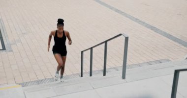 Merdivenler, koşan ve spor yapan siyah bir kadın, şehir ve zorluklara dayanıklılık ve ilerleme. Fitness, Afrikalı kişi ve atletle, eğitimle ya da nefes almayla ya da antrenmanlı kardiyoyla.