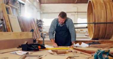 Olgun bir adam, marangoz ve mobilya ve tasarım atölyesinde çizim yapıyor. Marangozluk, marangozluk ve depo ahşap işçiliği ile yeni başlayan bir işin onarımı için ölçü.