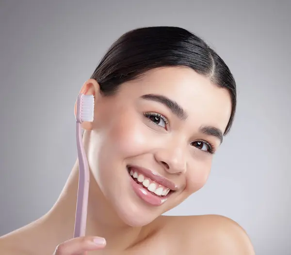 stock image Portrait, woman and brushing teeth with dental hygiene and wellness on grey studio background. Face, person or model with oral care, mouth health and cleaning with veneers, aesthetic or fresh breath.