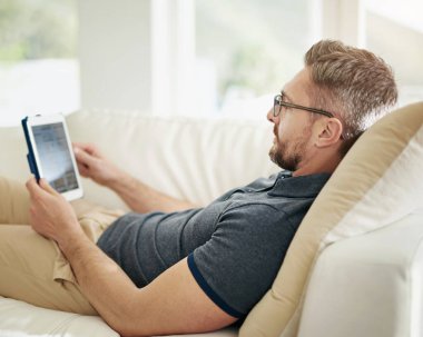 Dijital, ekran ve adam evdeki sosyal medya, arama ve internet aboneliği olan bir kanepede dinleniyor. Tablet, ecommerce ve oturma odası çevrimiçi alışveriş, uygulama veya menü seçimi.