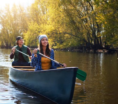 Lake, canoe and couple with adventure, travel and hobby with vacation, happiness and summer. River, happy man and woman with activity, honeymoon and nature with paddle, journey and bonding together.