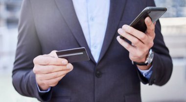 İş adamı, kredi kartı ve şehirdeki eller online alışveriş, mobil bankacılık ve gider takibi için akıllı telefon kullanıyor. İnsan, şirket ve detaylar veya ödeme, abonelik hizmeti ve satış için parola