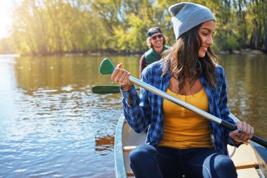 Couple, canoe and lake or forest holiday exploring or rowing outdoor, environment or journey. Man, woman and happy or travel weekend or river morning at vacation resort in Colorado, calm or island.