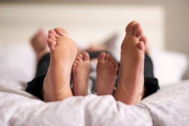 Aile ve çocuğun sevgi, yatak ve ayakları güven, sağlık ve bağlılık için hafta sonları bir arada. Aile evi, insan ve çocuk kumaş çarşafların altında rahatlamak ve yatak odasında uyumak için..