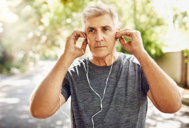 Mature man, music and headphones on street for running, fitness and exercise for wellness. Male runner, listening and audio for motivation with training, morning start to workout in New York City. clipart