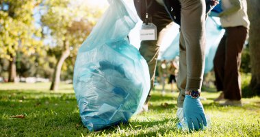El, insan ve hayırseverlik parktan temizlik, bakım ve kamu hizmeti için plastikle pislik topluyor. Gönüllü olarak çim, çöp ve kirlilik veya bakım, çevre ve sağlık.