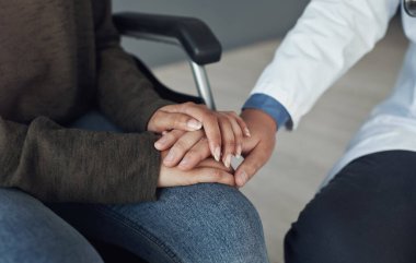 Doctor, patient and holding hands for medical support in hospital office with closeup, empathy and kindness. Professional, expert and woman with sympathy for healthcare results, diagnosis and health.