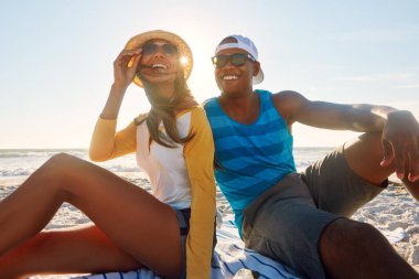 Piknik, çift ve plajda güneş gözlükleriyle mutlu, yaz tatilinde okyanus kıyısında seyahat ve dinlenme. Erkek, kadın ve Yunanistan 'da kumlara gülümse mavi gökyüzü, güneş ve partnerle bayram ya da aşk randevusunda.