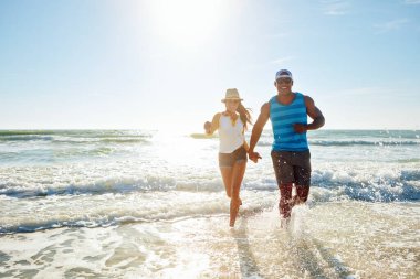 Çiftler, sahilde su sıçratır. Romantizm, tatil ve yaz tatili için. Heyecanlı insanlar aşk, eğlence ya da enerji ile el ele tutuşuyorlar. Yolculuk macerası ve sağlık ya da deniz sağlığı için..