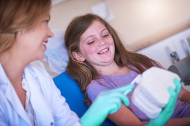 Hastanede diş fırçası, manken ya da oral sağlık eğitimi veren dişçi, kadın ve danışman kız. Çocuk, doktor ve diş beyazlatma için 3 boyutlu kalıplar sağlık için temizlik, yardım ve gülümseme ile klinikte.