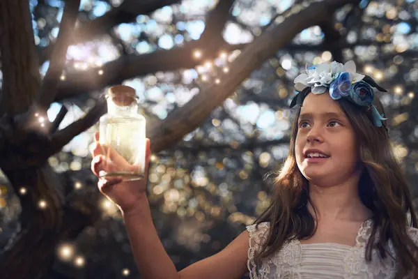 stock image Magic, jar and light outdoor in nature with glow, shine and young child playing in forest. Girl, smile and happy in woods as dream with fantasy for unique mystical fairy, bubble or folklore with tree.