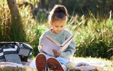 Çocuklar, öğrenme ve bahçede kitap okumak, piknik yapmak ve doğada çocuk gelişimi için bir kız. Barış, fantezi ya da masal, öykü ve okuma yazma bilen çocuk, eğitim ya da hobi.