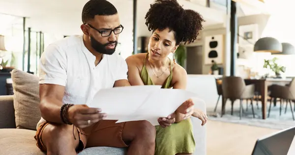 stock image Couple, paperwork and budget on sofa in home for mortgage loan, investment planning and bills. People, technology and finance documents in living room with invoice for expenses, savings and taxes.